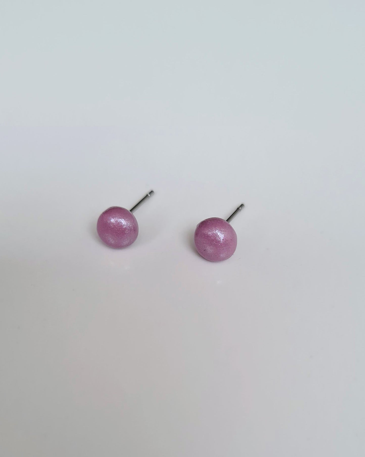 Pair of Lavender coloured pearlescent studs on a light grey background