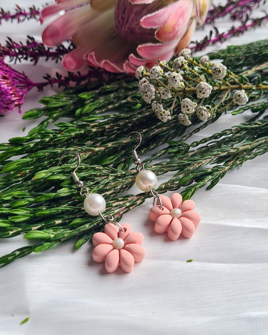 Floral earrings with pink flowers on a white background